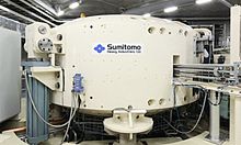 Proton therapy cyclotron with robotized positioning table